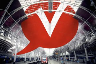 Überdimensionale Grafik des Verso-Logos in rot in einer Bahnhofshalle