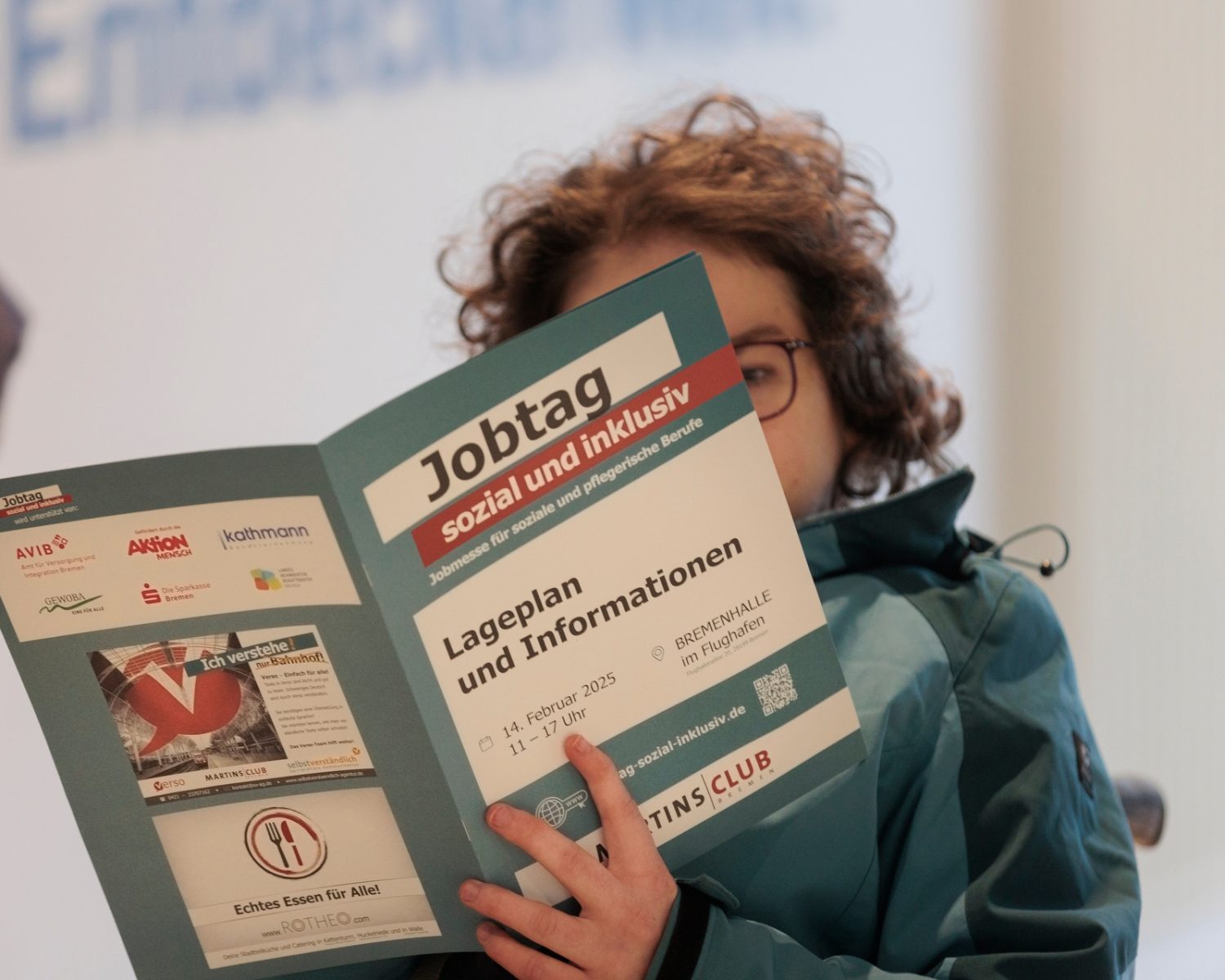 Eine Frau schaut sich eine Info-Broschüre zum Jobtag an.