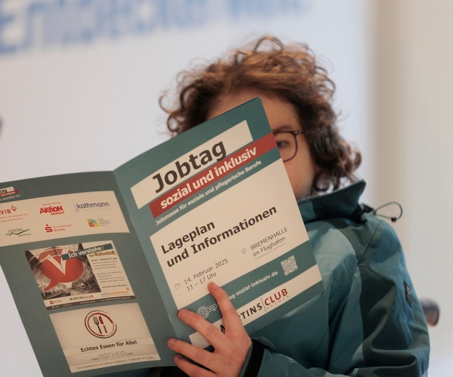 Eine Frau schaut sich eine Info-Broschüre zum Jobtag an.